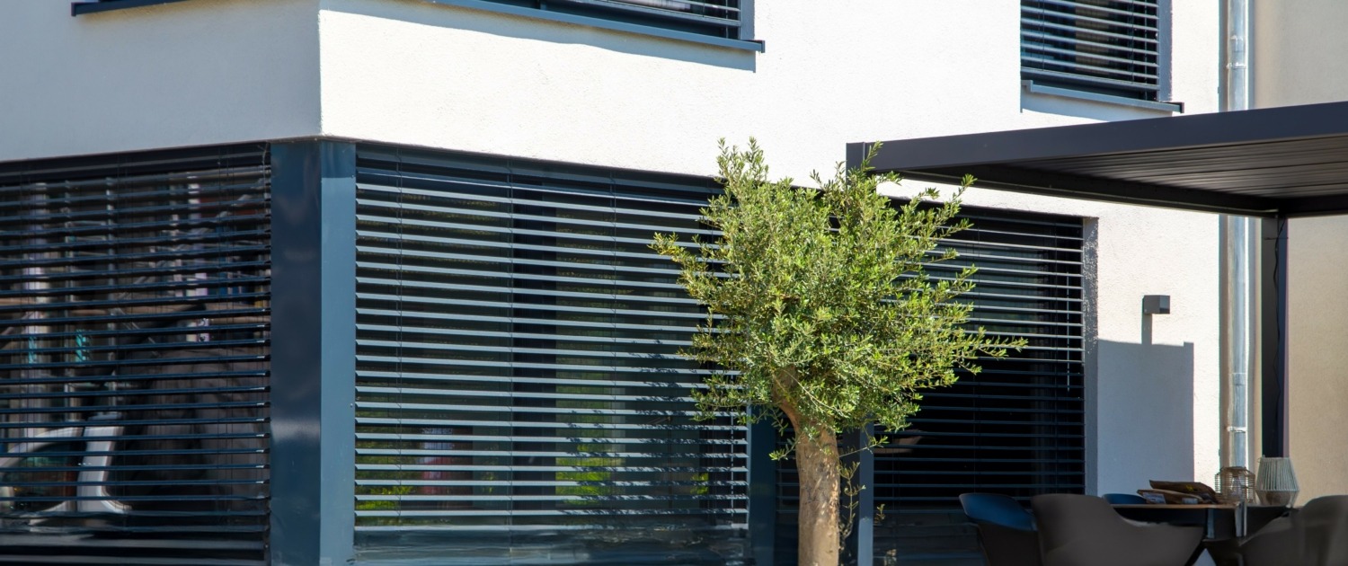 Modern blinds on a sliding window with access to the garden terrace